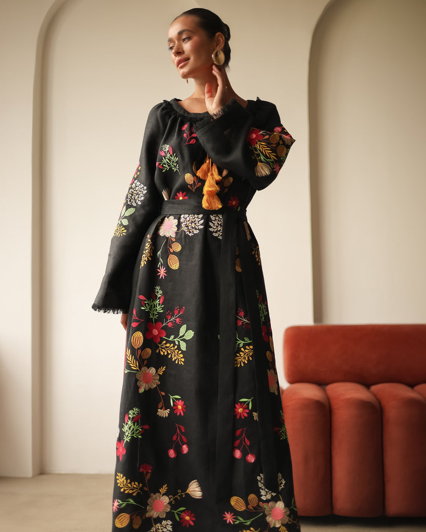 Full-length view of model posing in black floral embroidered linen kaftan maxi dress with bell sleeves — Zalxndra Resort
