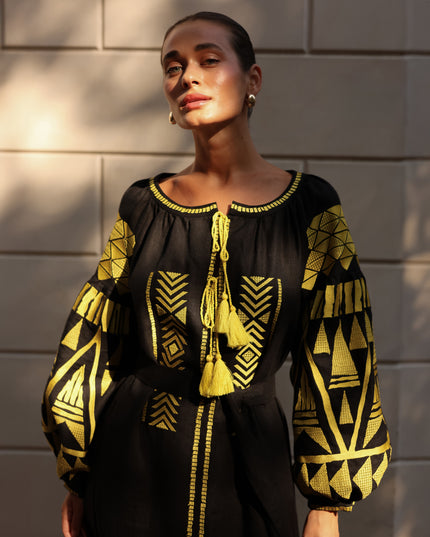 Black linen kaftan maxi dress with gold geometric embroidery, balloon sleeves and gold tassel ties, editorial view - Zalxndra Resort