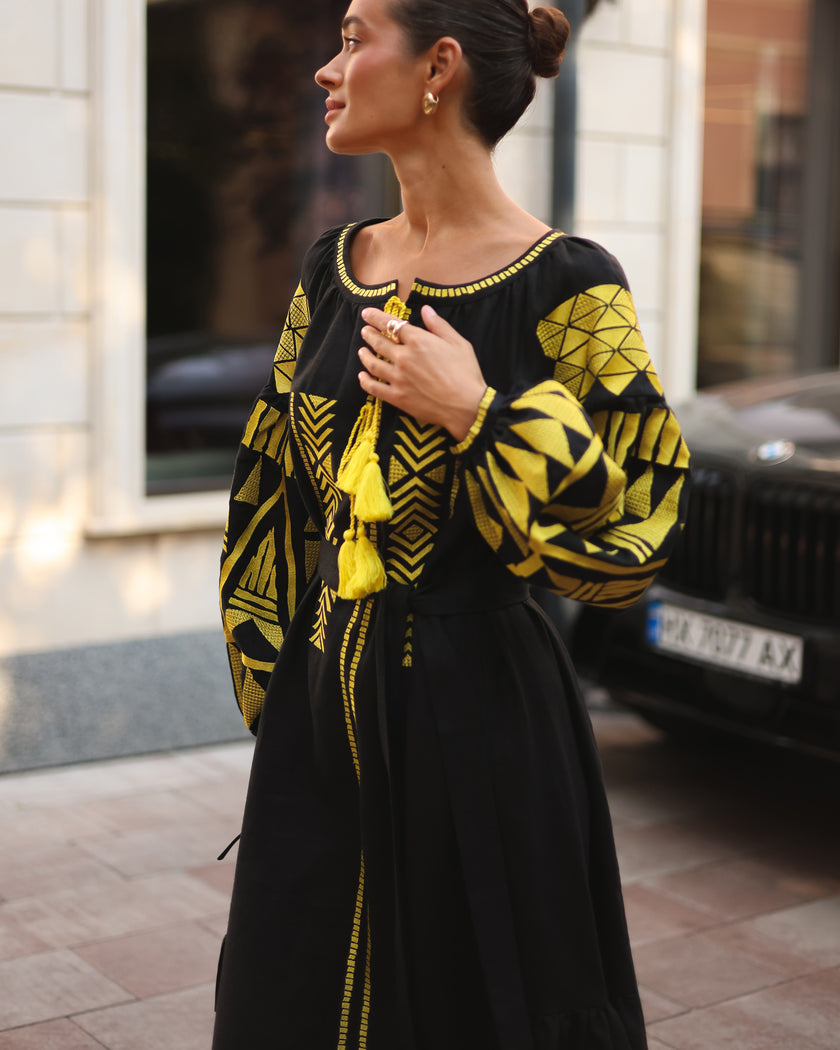 Black linen kaftan maxi dress with gold geometric embroidery, balloon sleeves and gold tassel ties, side profile view - Zalxndra Resort