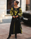 Black linen kaftan maxi dress with gold geometric embroidery, balloon sleeves and gold tassel ties, styled with black clutch and boots, full length view - Zalxndra Resort