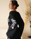 Back view of black linen kaftan maxi dress with pastel floral embroidery and frayed bell sleeves - Zalxndra Resort