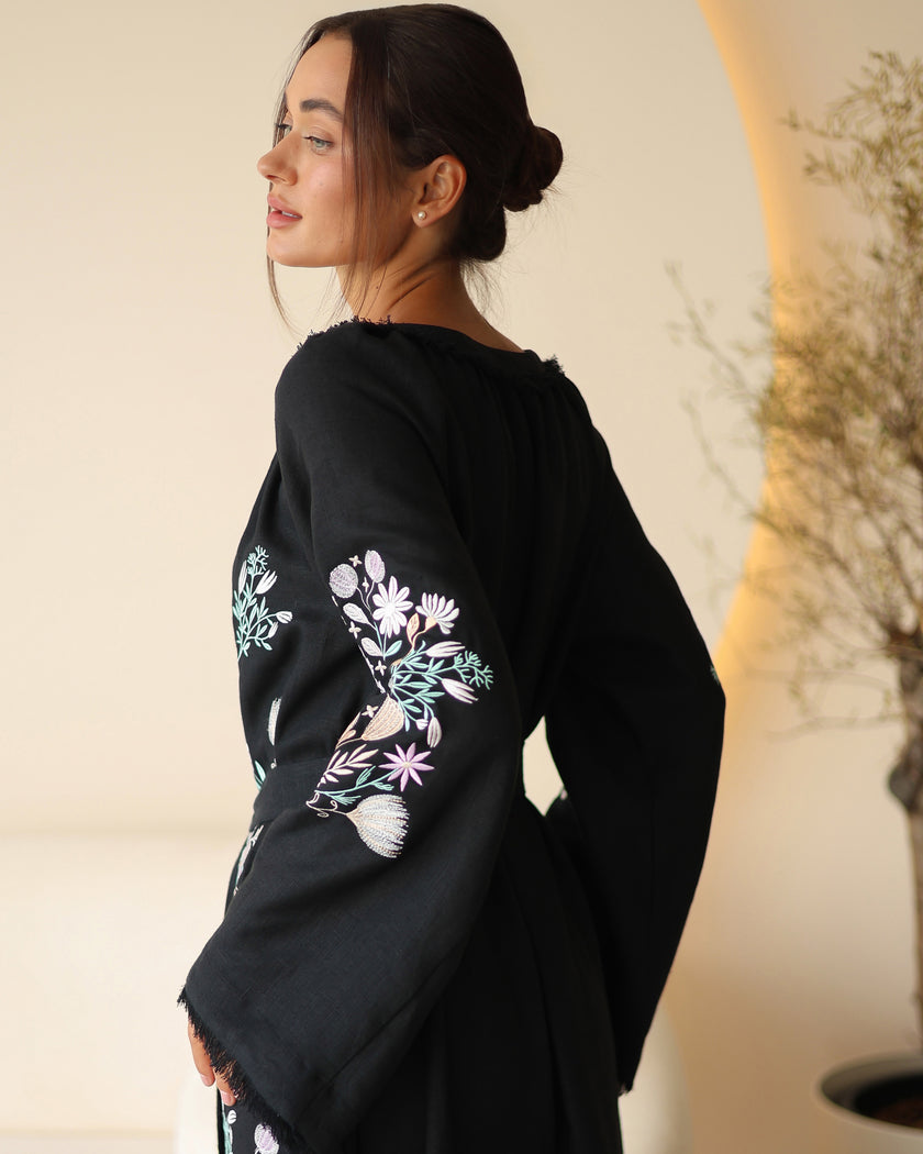 Back view of black linen kaftan maxi dress with pastel floral embroidery and frayed bell sleeves - Zalxndra Resort