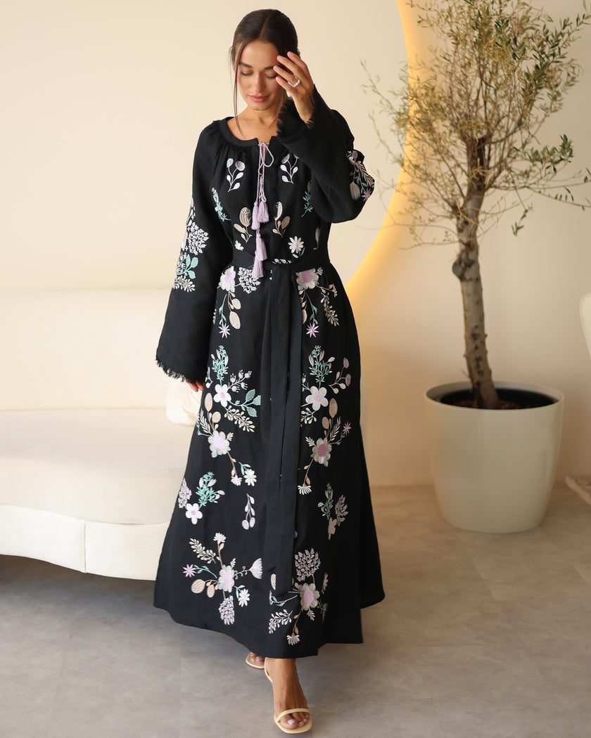 Full-length view of black linen kaftan maxi dress with pastel floral embroidery, frayed bell sleeves, and lilac tassel ties - Zalxndra Resort