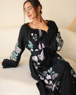 Portrait view of black linen kaftan maxi dress with pastel floral embroidery and lilac tassel ties - Zalxndra Resort