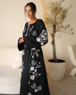 Black linen kaftan maxi dress with pastel floral embroidery and lilac tassel ties styled portrait - Zalxndra Resort