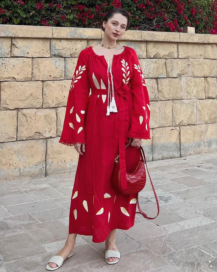Scarlet red linen kaftan maxi dress with gold leaf embroidery, angel sleeves, frayed trim and tassel tie belt, styled with red handbag, lifestyle view - Zalxndra Resort