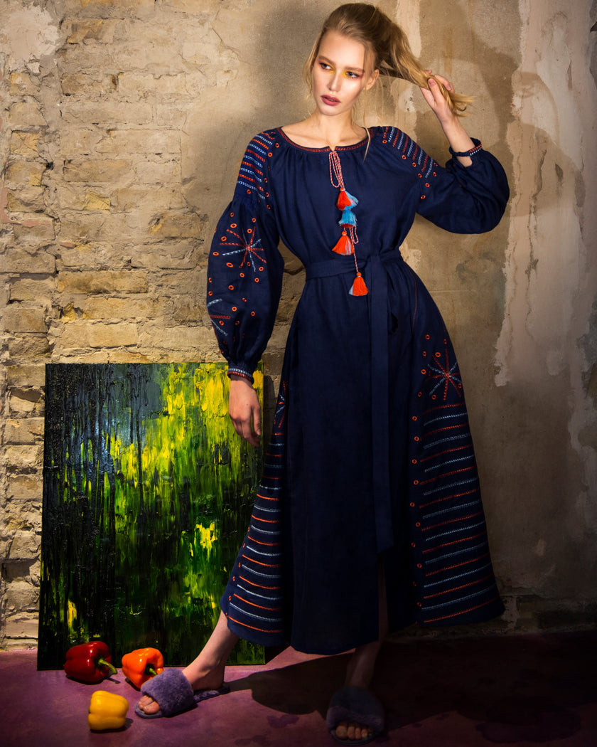 Editorial shot of model in navy linen kaftan maxi dress with orange and blue geometric embroidery, balloon sleeves, and tassel ties - Zalxndra Resort