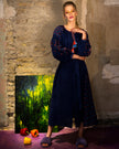Full-length editorial of model in navy linen kaftan maxi dress with orange and blue geometric embroidery and tassel ties - Zalxndra Resort