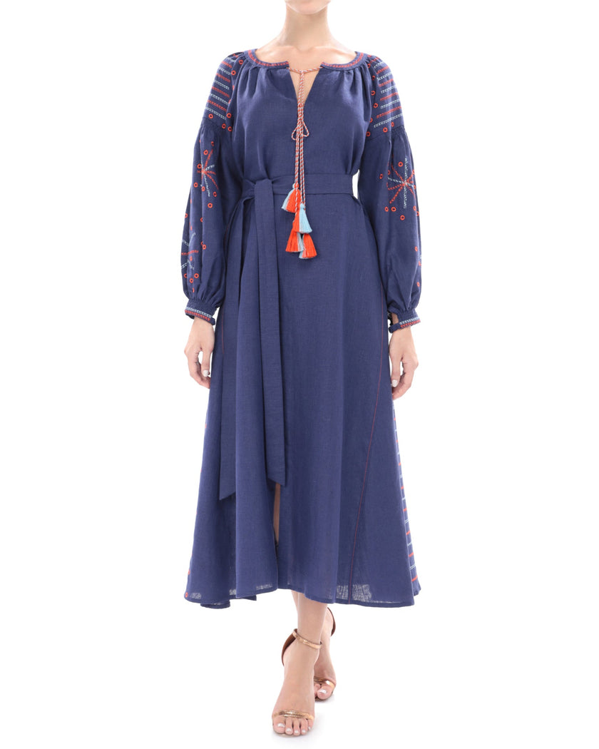Model styled in navy linen kaftan maxi dress with orange and blue geometric embroidery, balloon sleeves, and tassel ties - Zalxndra Resort