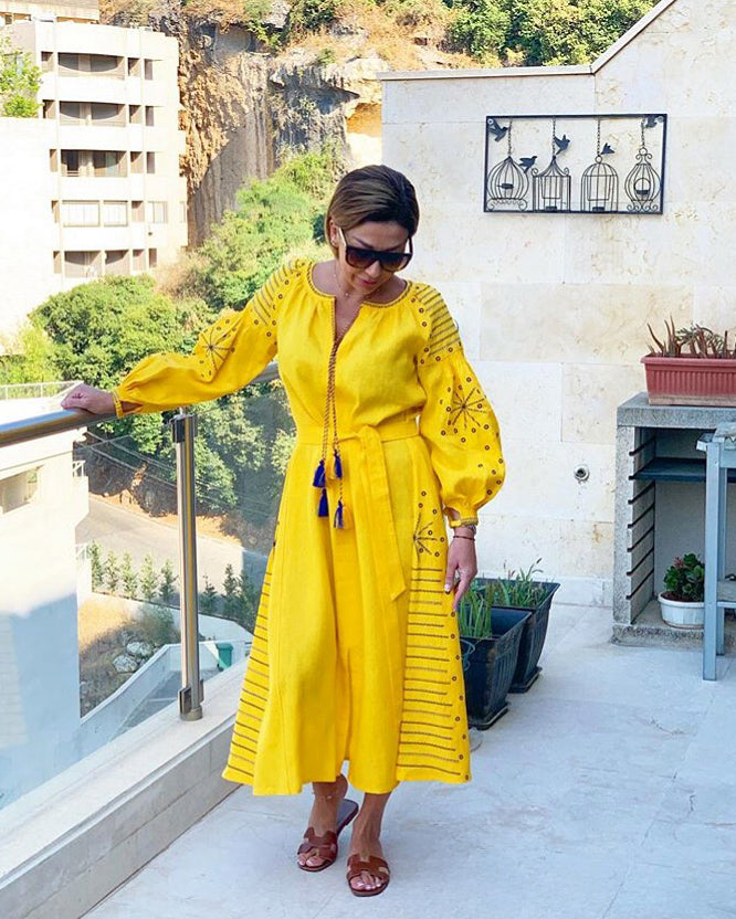 Saffron yellow linen kaftan maxi dress with navy geometric embroidery, balloon sleeves and tassel tie belt, styled on balcony, portrait view - Zalxndra Resort