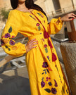 Saffron yellow linen kaftan maxi dress with multicolour floral embroidery, balloon sleeves, and tassel ties, editorial outdoor setting - Zalxndra Resort