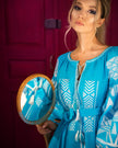 Turquoise linen kaftan maxi dress with white geometric embroidery, balloon sleeves and white tassel ties, bodice detail view - Zalxndra Resort