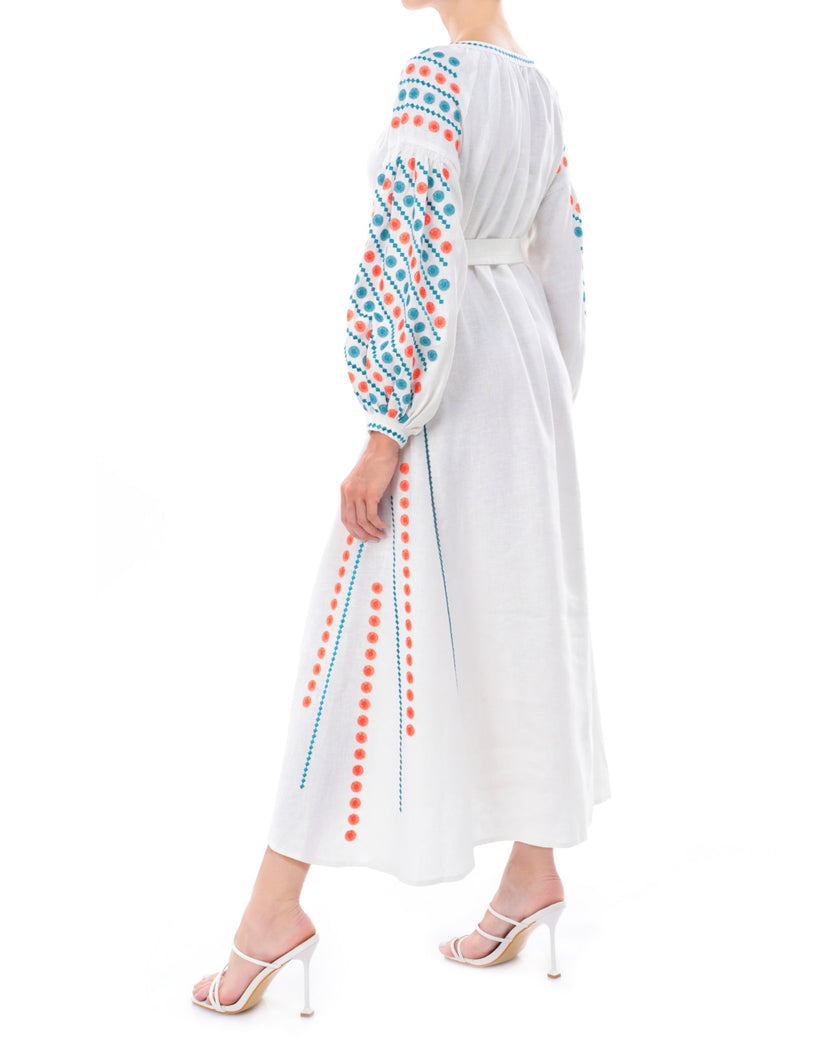 White linen maxi dress with teal and orange geometric embroidery, balloon sleeves and tie waist, side profile view - Zalxndra Resort
