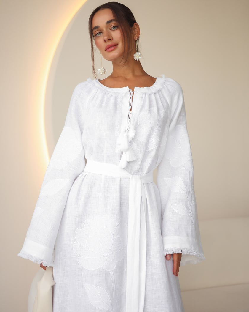 Portrait view of white linen kaftan maxi dress with tonal floral embroidery, frayed bell sleeves, and tassel ties - Zalxndra Resort