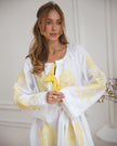 Bodice detail of white linen kaftan maxi dress with yellow floral embroidery, frayed angel sleeves, and tassel tie - Zalxndra Resort