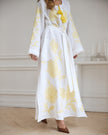 Full-length view of white linen kaftan maxi dress with yellow floral embroidery, frayed angel sleeves, and tassel tie - Zalxndra Resort