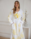 Portrait view of white linen kaftan maxi dress with yellow floral embroidery, angel sleeves, and tassel tie - Zalxndra Resort