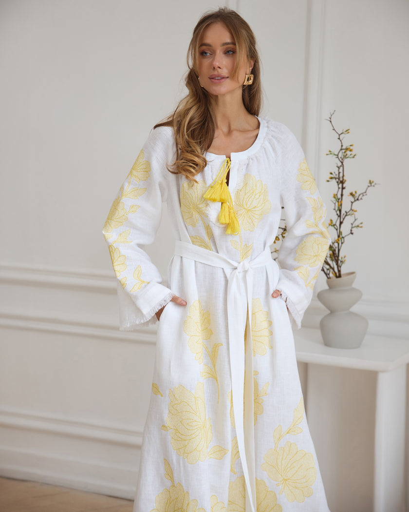 Portrait view of white linen kaftan maxi dress with yellow floral embroidery, angel sleeves, and tassel tie - Zalxndra Resort