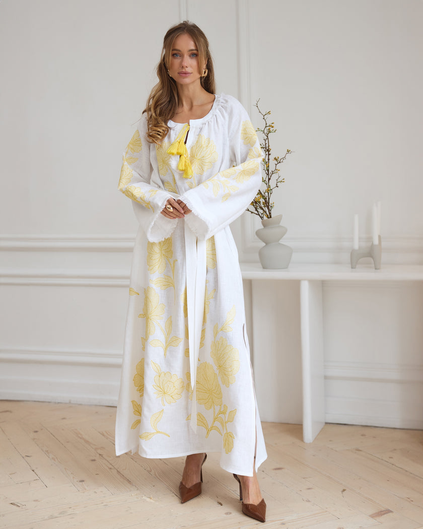 White linen kaftan maxi dress with yellow floral embroidery, angel sleeves, and tassel tie styled portrait - Zalxndra Resort