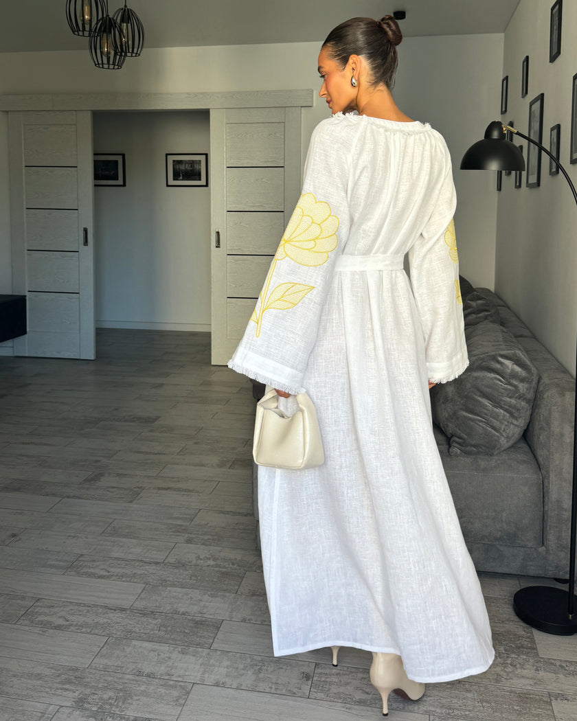 Back styled view of white linen kaftan maxi dress with yellow outlined floral embroidery and angel sleeves - Zalxndra Resort
