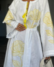 Bodice detail of white linen kaftan maxi dress with yellow outlined floral embroidery, frayed angel sleeves, and tassel tie - Zalxndra Resort