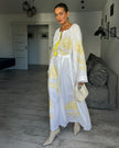Full-length view of white linen kaftan maxi dress with yellow outlined floral embroidery, angel sleeves, and tassel tie - Zalxndra Resort